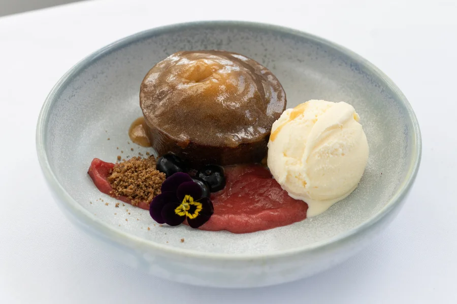 Sticky Date Pudding (NF) Ceylon vanilla ice cream – Rhubarb compote – Lemon myrtle and banana soil Sticky Date Pudding (NF) Ceylon vanilla ice cream – Rhubarb compote – Lemon myrtle and banana soil
