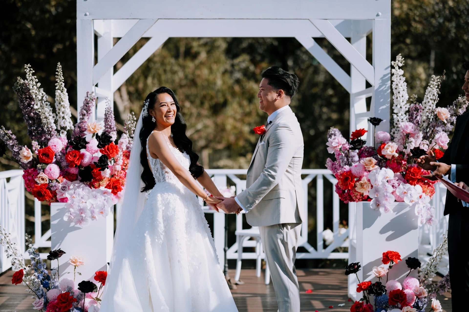 An Asian couple holding hands and laughing after outdoor wedding ceremony at Melbourne wedding venue