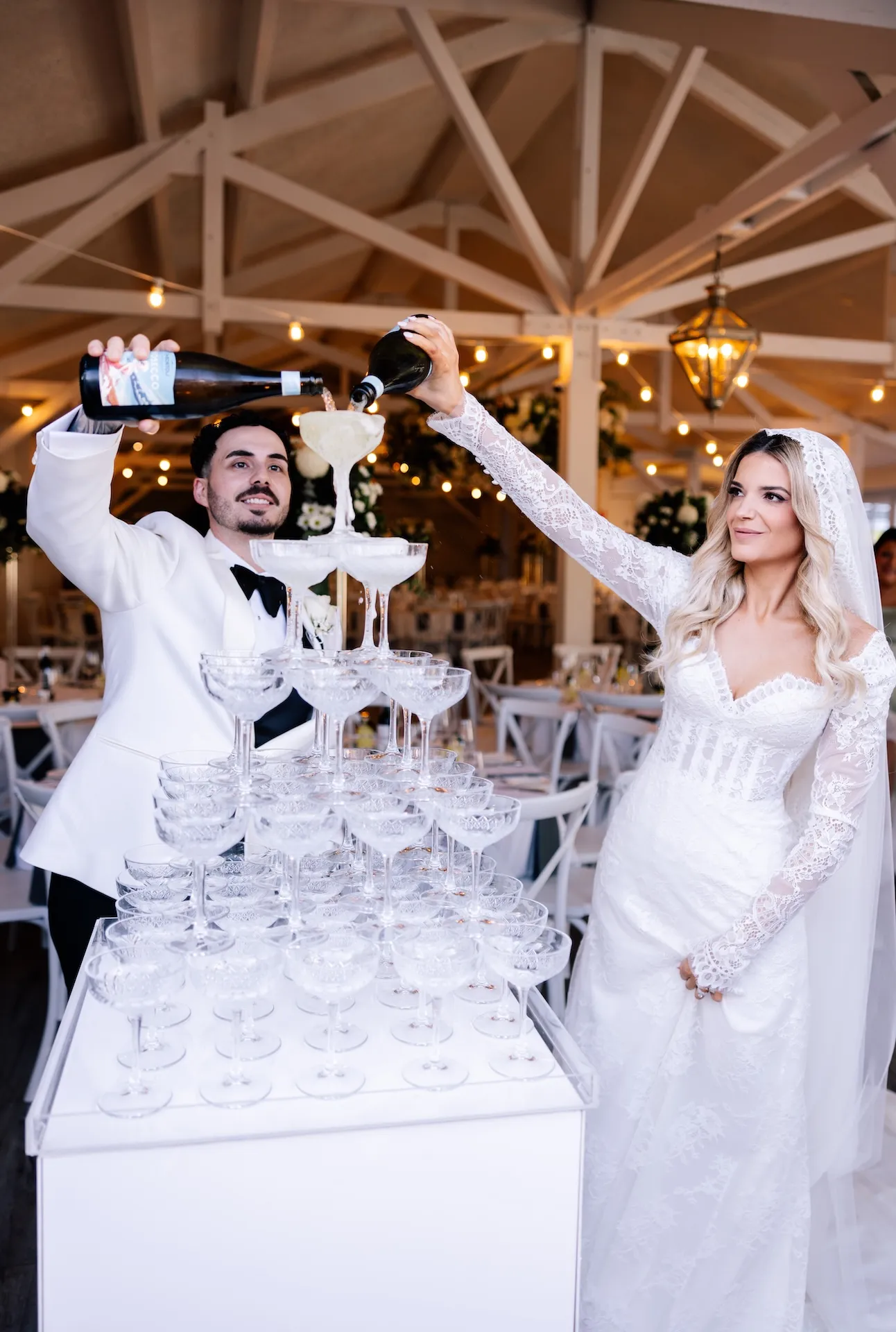 Bride and groom pouring champagne into tower at Melbourne wedding reception venue