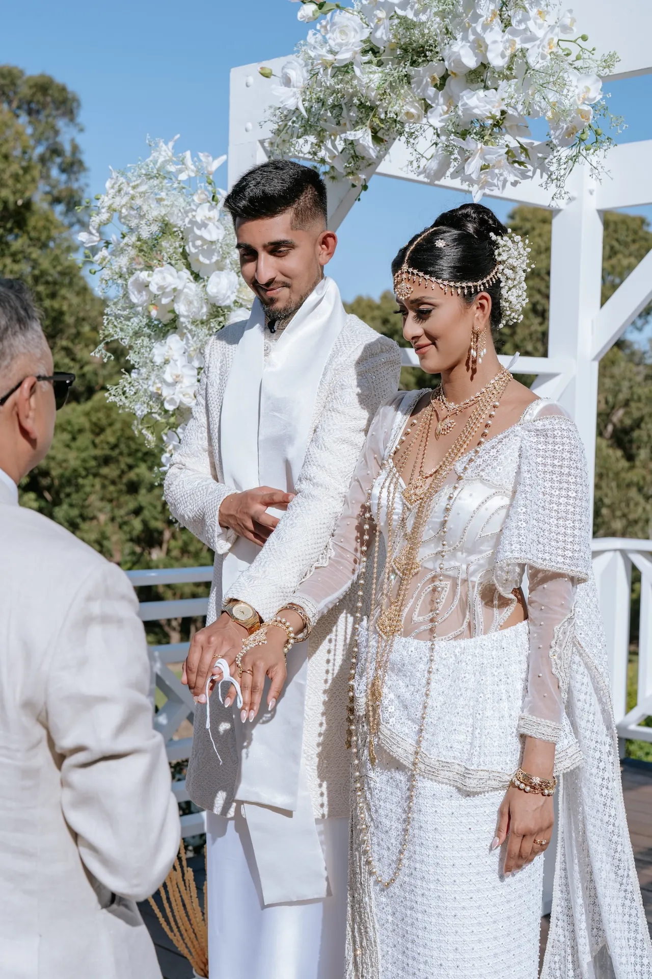 Hindu couple in white wedding outfit during ceremony